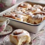 Freshly baked easiest cinnamon rolls drizzled with icing on a plate.