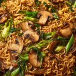 Bowl of homemade Asian mushroom ramen noodles topped with fresh herbs.